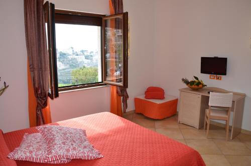 1 dormitorio con cama, ventana y escritorio en Pinguino B&B en Scala