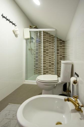 a white bathroom with a toilet and a sink at Lagar do Sapateiro in Fontes