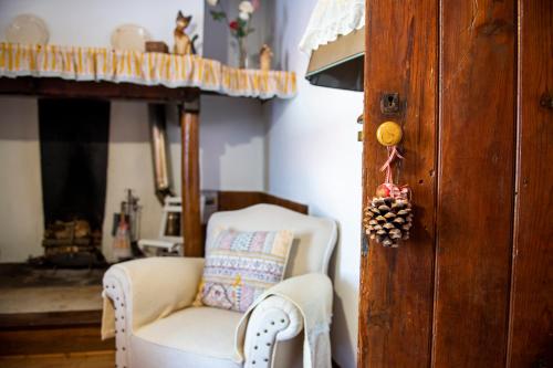 a living room with a chair and a fireplace at Lagar do Sapateiro in Fontes