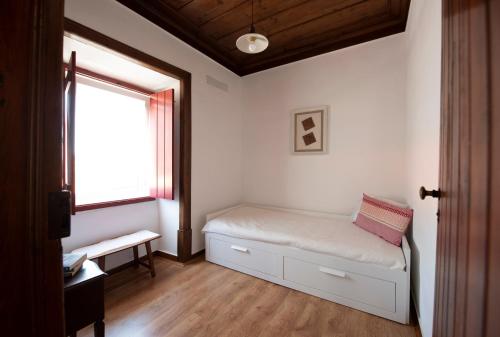 a small bedroom with a bed and a window at Lagar do Sapateiro in Fontes