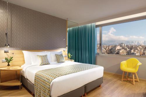 a hotel room with a bed and a large window at Wyndham Grand Athens in Athens