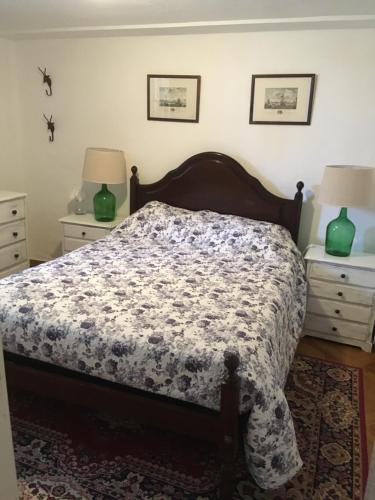 a bed in a bedroom with two night stands and two lamps at Casa Glória in Tomar