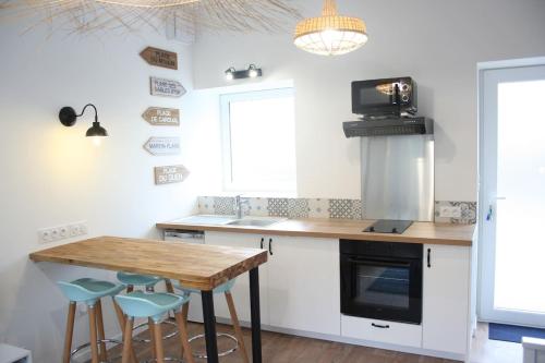 - une cuisine avec une table en bois et des tabourets bleus dans l'établissement Superbe Maison 4 personnes entre le port et le centre, COUR PRIVATIVE, WiFi & Netflix gratuits, à Saint-Brieuc