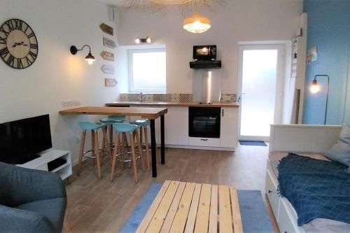 Il comprend une cuisine et un salon avec une table et des chaises. dans l'établissement Superbe Maison 4 personnes entre le port et le centre, COUR PRIVATIVE, WiFi & Netflix gratuits, à Saint-Brieuc