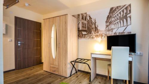 a home office with a desk and a television at Schroeders City-Style-Hotel in Trier