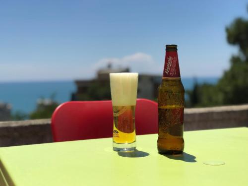 una botella de cerveza y un vaso sobre una mesa en Hotel Gega, en Durrës