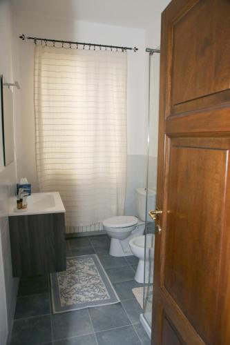 a bathroom with a toilet and a sink and a door at DOLCE VITA in Tempio Pausania
