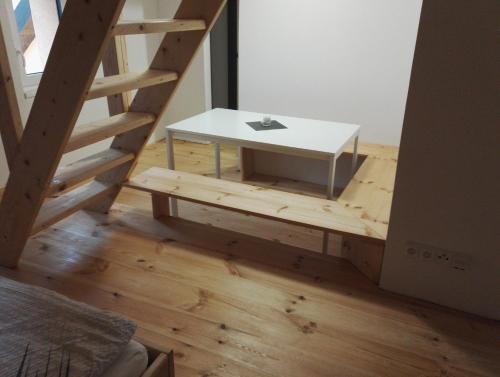 a white table sitting on the floor next to a staircase at Horská chata Plzeňka Pernink in Pernink