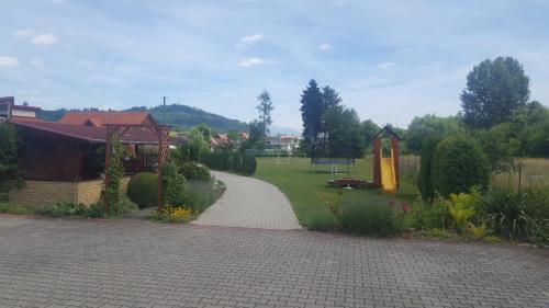 a garden with a walkway and a park with a playground at Penzion Mirabel in Bešeňová