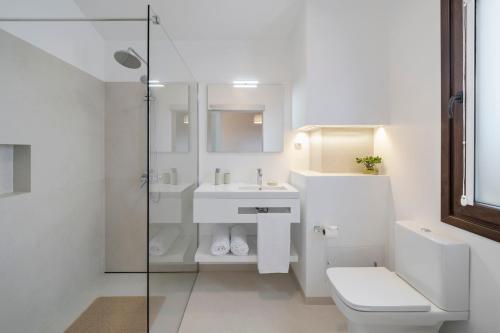 Baño blanco con aseo y lavamanos en Southern Sunny House by An Island Apart, en Calheta