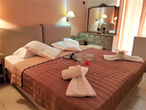 a bedroom with a bed with towels and a mirror at Mitho Hotel Spa in Loutra Edipsou