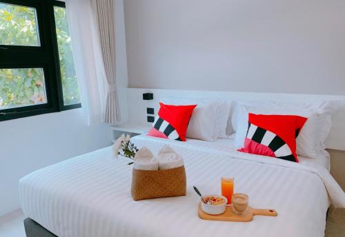 a bedroom with two beds with red and white pillows at Blue Tao Beach Hotel - SHA Plus in Koh Tao