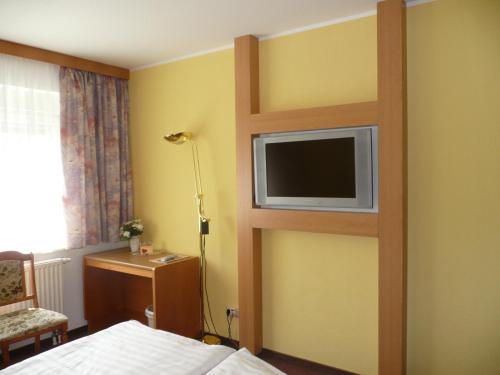 a bedroom with a tv on a wall at Hotel Garden in Bautzen