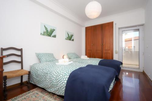 a bedroom with a bed and a table and a chair at Sea View Apartment in Figueira da Foz