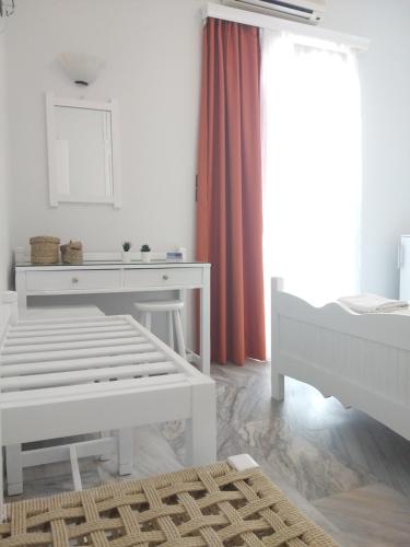 a white room with a bench and a table at Syrianos Hotel in Naxos Chora