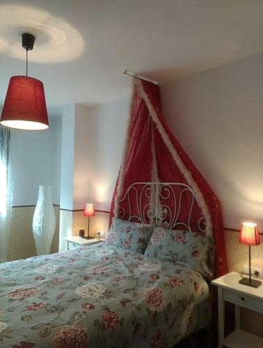 a bedroom with a bed with a red headboard and two lamps at En plena Ribera Sacra CasaCocó in Ferreira