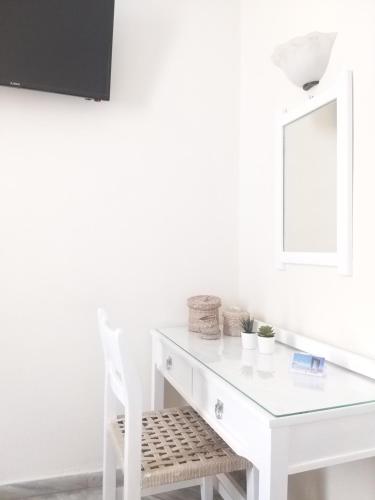 a white desk with a white chair and a mirror at Syrianos Hotel in Naxos Chora