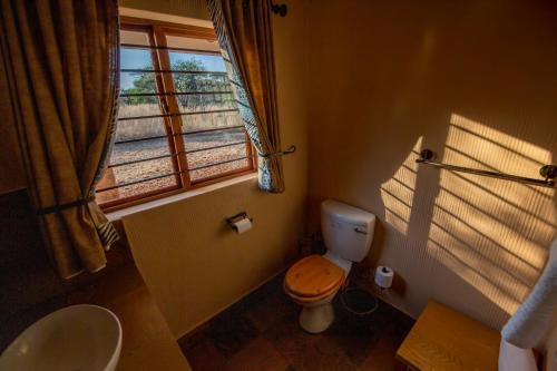 a bathroom with a toilet and a window at Makhato Bush Lodge 111 in Bela-Bela