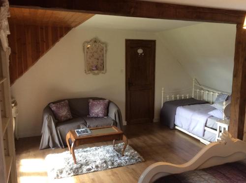 uma sala de estar com um sofá e uma cama em Spruce Lake em Sauviat-sur-Vige