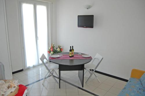 a dining room with a table and chairs and a tv at Residence Sangiorgi in Cattolica