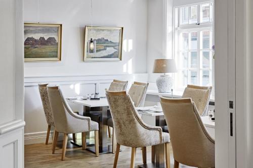 a dining room with a table and chairs at Duus Hotel garni in Wyk auf Föhr