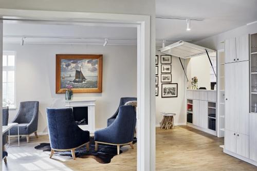 a living room with blue chairs and a fireplace at Duus Hotel garni in Wyk auf Föhr