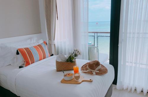 a hotel room with a bed with a view of the ocean at Blue Tao Beach Hotel - SHA Plus in Koh Tao