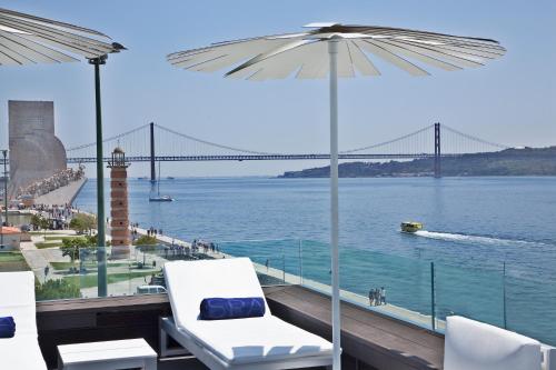 a balcony with a view of the water and a bridge at Altis Belem Hotel & Spa - Design Hotels in Lisbon