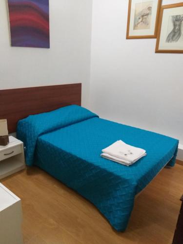 a bed in a room with a blue comforter at Hostal Africa Do Sul in Lisbon