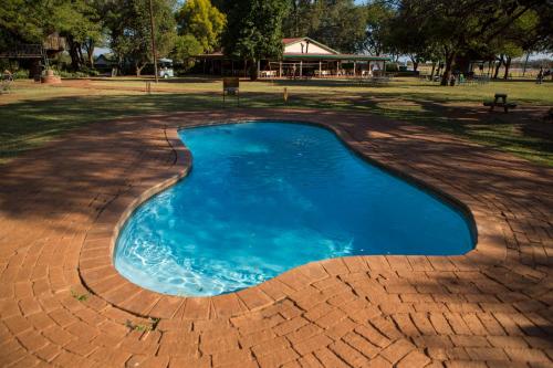 a small swimming pool on a brick patio at Makhato Bush Lodge 111 in Bela-Bela