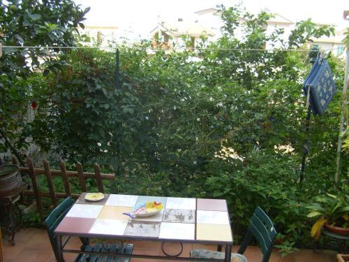a table and chairs in front of a garden at Bed & Breakfast 5 Di Spade in Gioiosa Marea
