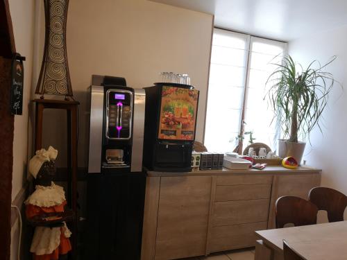 a kitchen with a vending machine next to a table at Le Saint Mary in Mauriac