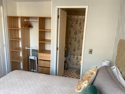 a bedroom with a bed and a door to a bathroom at Stay Santiago Lastarria Bellas Artes in Santiago