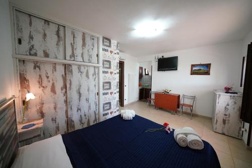 a bedroom with a blue bed with towels on it at Villa Belvedere in Ostuni