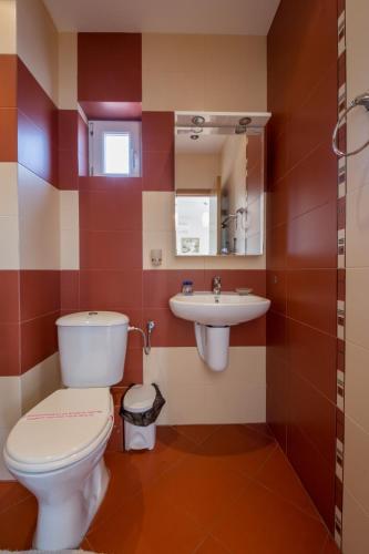 a bathroom with a toilet and a sink at Семеен хотел Бриз in Sozopol