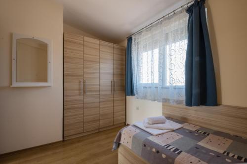 a bedroom with a bed and a window at Hotel Briz in Sozopol