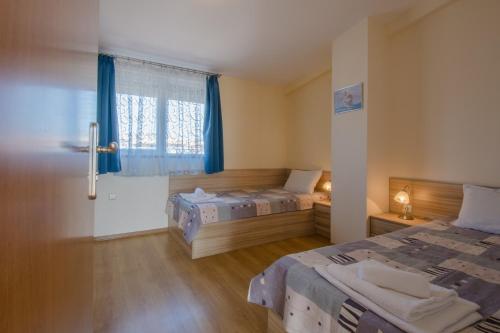 a bedroom with two beds and a window at Семеен хотел Бриз in Sozopol