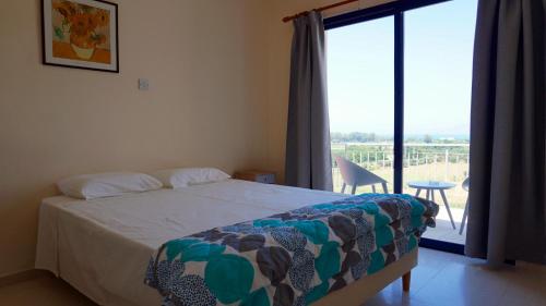 a bedroom with a bed and a window with a view at Panoramic sea view apartment in Polis-Latchi in Polis Chrysochous
