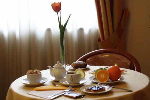 a table with cups and plates of food on it at Hotel Europa in Naples