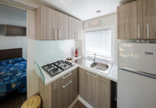 a small kitchen with a stove and a sink at Camping Rose in Dormelletto