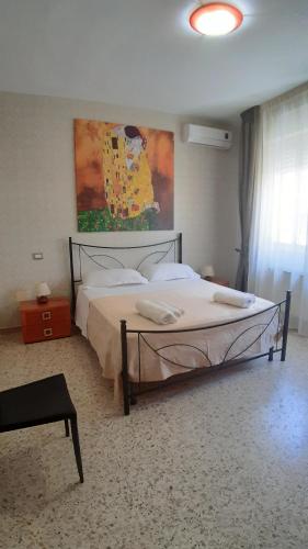 a bedroom with a bed and a painting on the wall at Domus Salentina in Leverano