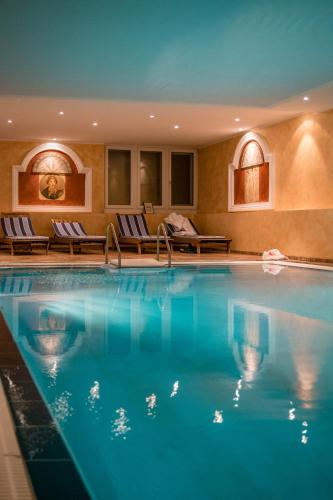 a large swimming pool in a hotel with lounge chairs at Residence Bellevue in Boppard