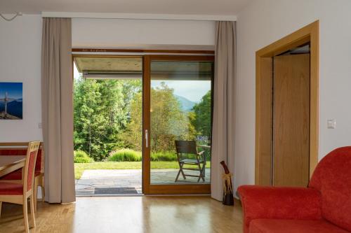 a living room with a door open to a patio at Gartenlodge Auszeit in Nötsch