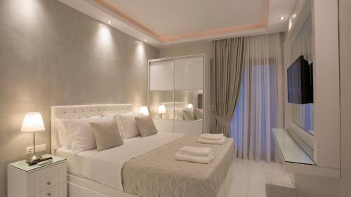 a bedroom with a white bed with towels on it at Amaryllis Luxury Rooms in Platamonas