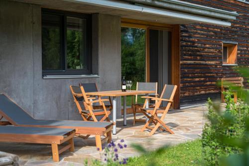 a patio with a table and chairs on a patio at Gartenlodge Auszeit in Nötsch