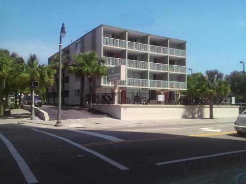 a building on the corner of a street with palm trees at Breakers Resort Hotel in Myrtle Beach