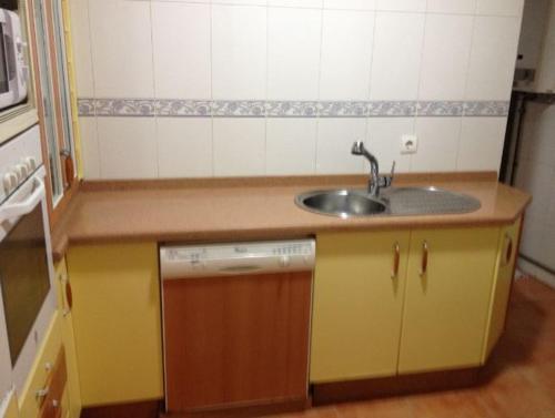una pequeña cocina con fregadero y lavavajillas en Vive Huelva ARAGON 4 HABITACIONES WIFI 300MB en Huelva
