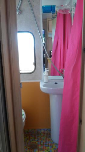 baño con lavabo y cortina de ducha rosa en Chalet en oasis privado, en La Vegueta