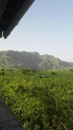 a view of a green field with mountains in the background at Cote de France in Fundura