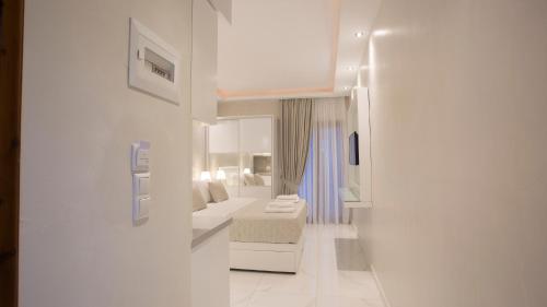 a white room with a bed and a mirror at Amaryllis Luxury Rooms in Platamonas